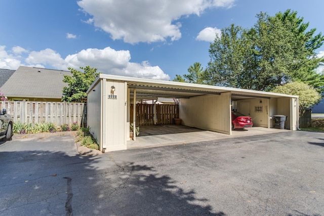 garage with a carport and fence