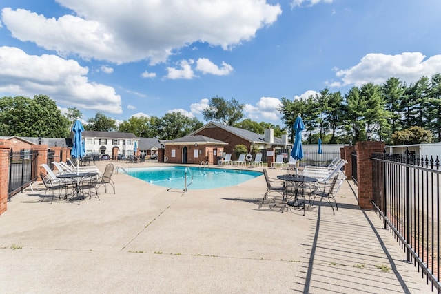 pool with a patio and fence