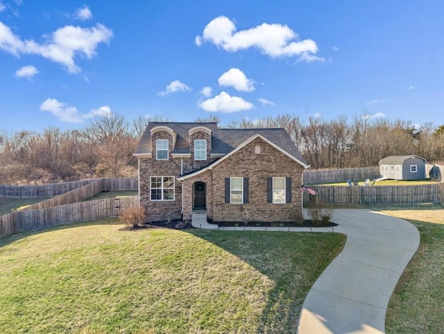 view of front of house featuring brick siding, fence, and a front lawn