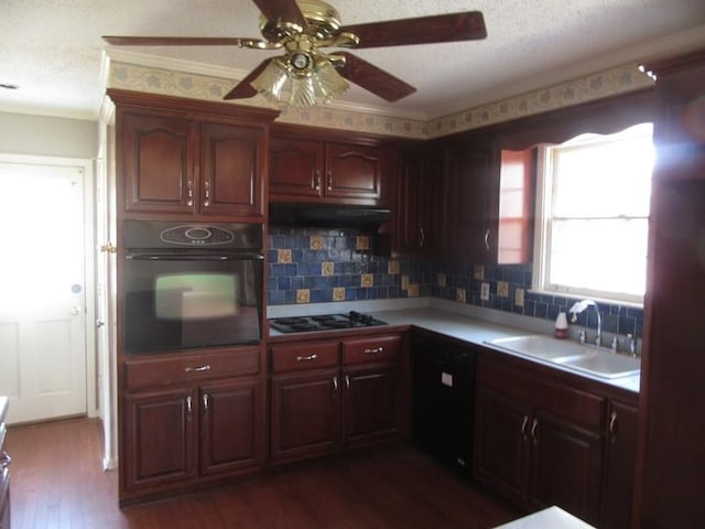 kitchen featuring dark wood-style floors, under cabinet range hood, light countertops, black appliances, and a sink