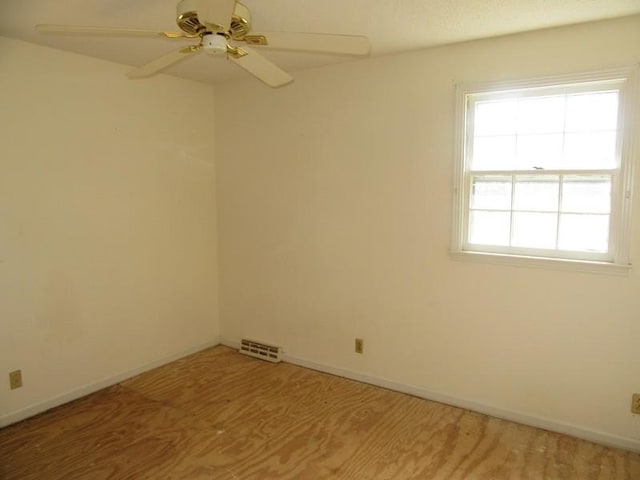 empty room with light wood-style floors, baseboards, visible vents, and a ceiling fan