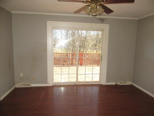 unfurnished room with ornamental molding, dark wood-style flooring, visible vents, and baseboards