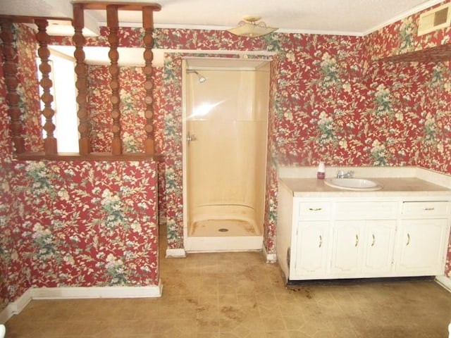 full bath with visible vents, a stall shower, vanity, baseboards, and wallpapered walls