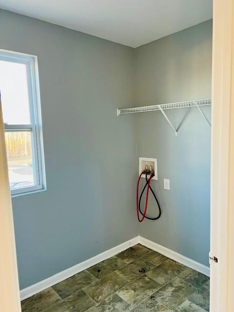 clothes washing area featuring laundry area, hookup for a washing machine, and baseboards