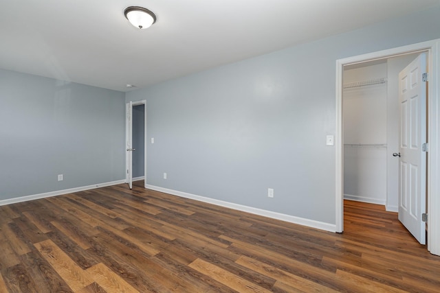 spare room with dark wood-style floors and baseboards