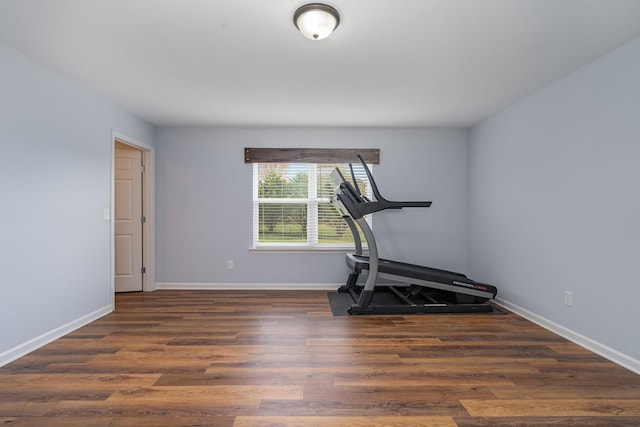 workout area with baseboards and wood finished floors