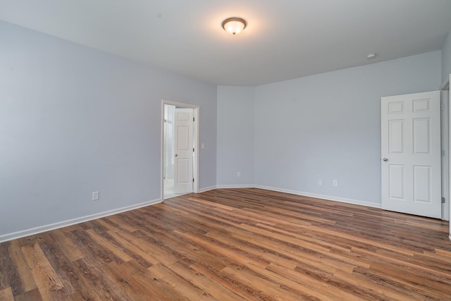 unfurnished room featuring wood finished floors and baseboards