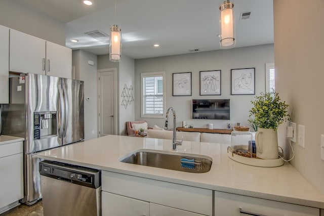 kitchen with light countertops, visible vents, appliances with stainless steel finishes, white cabinets, and a sink