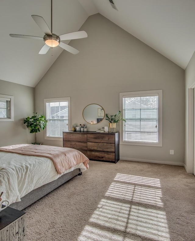 carpeted bedroom with high vaulted ceiling, ceiling fan, multiple windows, and baseboards