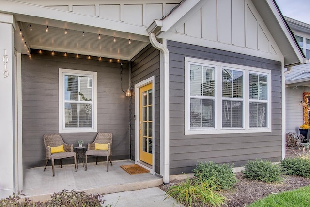 view of exterior entry featuring covered porch and board and batten siding