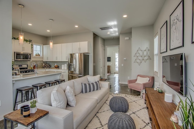 living room featuring recessed lighting and visible vents