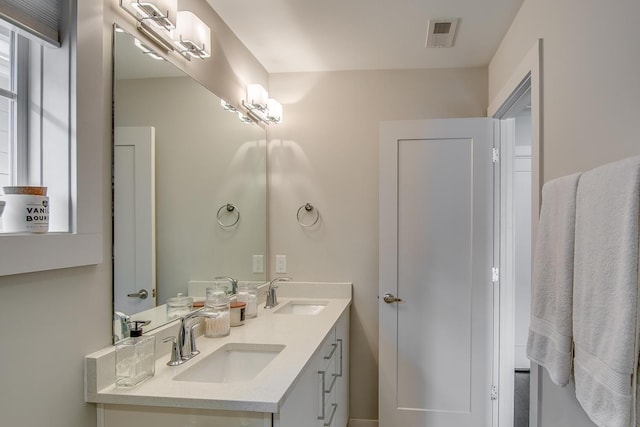 full bath featuring double vanity, visible vents, and a sink