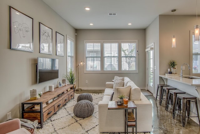 living area with recessed lighting, visible vents, and baseboards