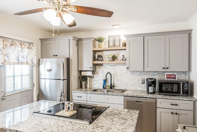 kitchen with gray cabinetry, a sink, appliances with stainless steel finishes, open shelves, and tasteful backsplash