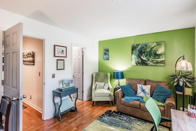 living area with baseboards and wood finished floors