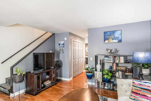 living area with baseboards and wood finished floors