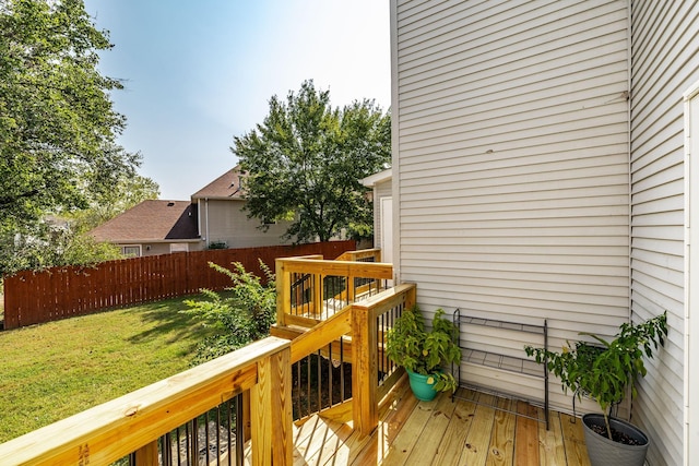 wooden deck featuring fence and a lawn