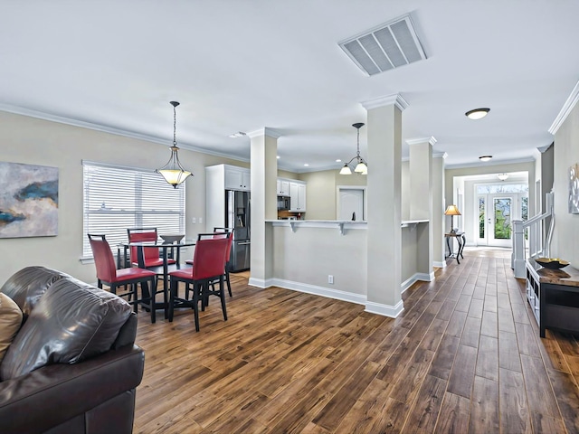 dining space featuring dark wood-style flooring, french doors, ornate columns, visible vents, and baseboards