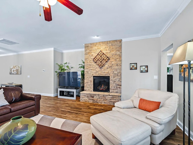 living room with ceiling fan, a fireplace, wood finished floors, baseboards, and ornamental molding