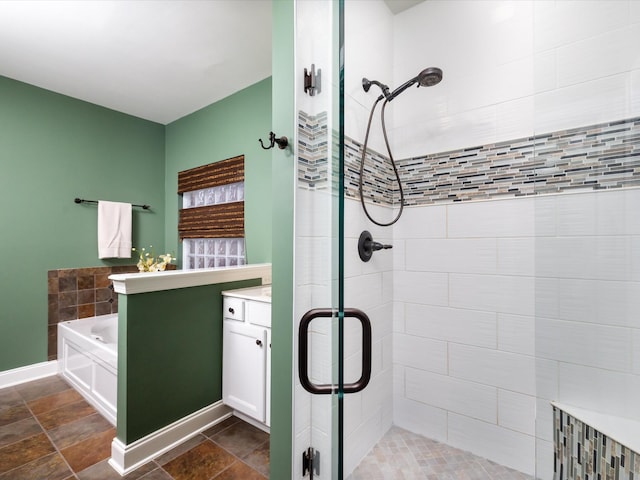 full bathroom with baseboards, a shower stall, vanity, and a bath