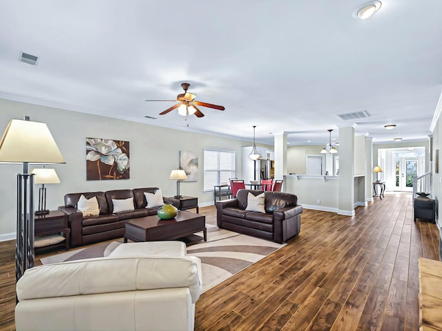 living room with ornamental molding, dark wood-style flooring, and visible vents