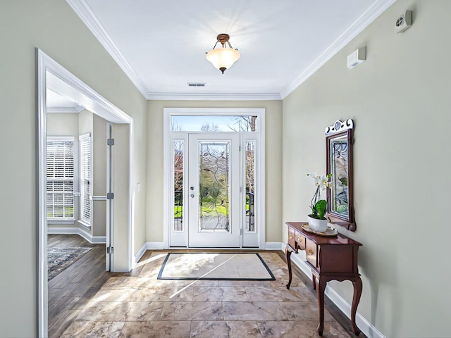 foyer entrance with visible vents, crown molding, and baseboards