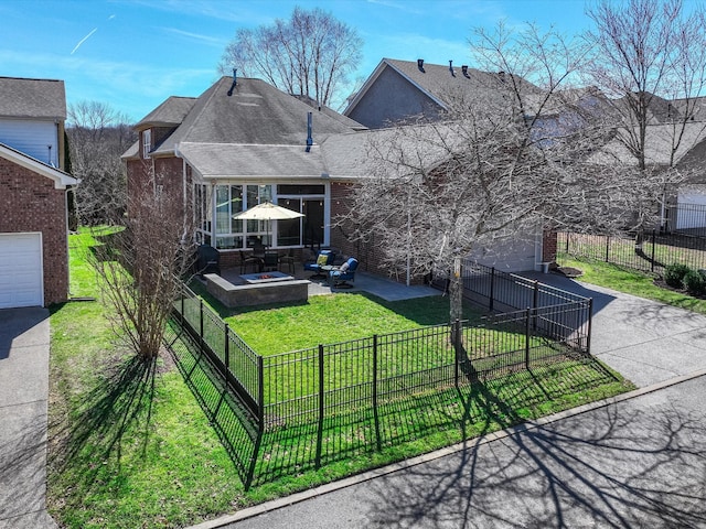 exterior space featuring driveway, a fire pit, fence, a yard, and brick siding