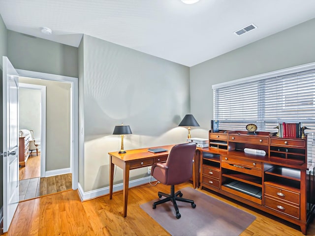 office featuring visible vents, baseboards, and wood finished floors