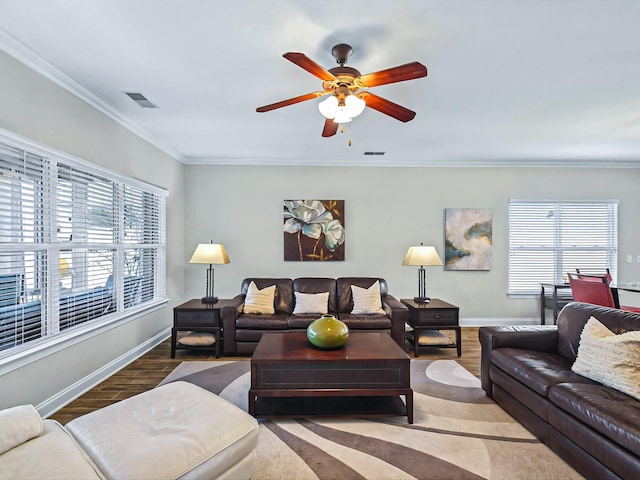 living room with visible vents, crown molding, baseboards, and wood finished floors