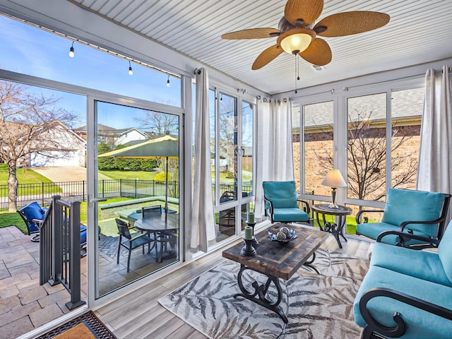 sunroom / solarium featuring ceiling fan