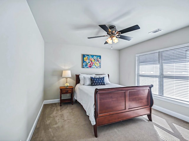 carpeted bedroom with baseboards, visible vents, and a ceiling fan