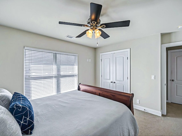 bedroom featuring a closet, visible vents, carpet flooring, ceiling fan, and baseboards