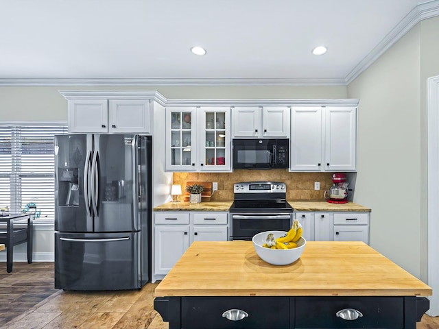 kitchen featuring black microwave, white cabinets, stainless steel range with electric cooktop, refrigerator with ice dispenser, and wooden counters