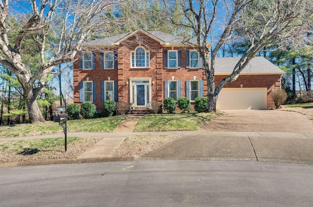 colonial inspired home featuring driveway, brick siding, an attached garage, and a front yard