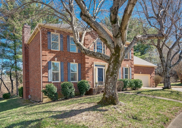 colonial-style house with an attached garage, a chimney, a front lawn, and brick siding