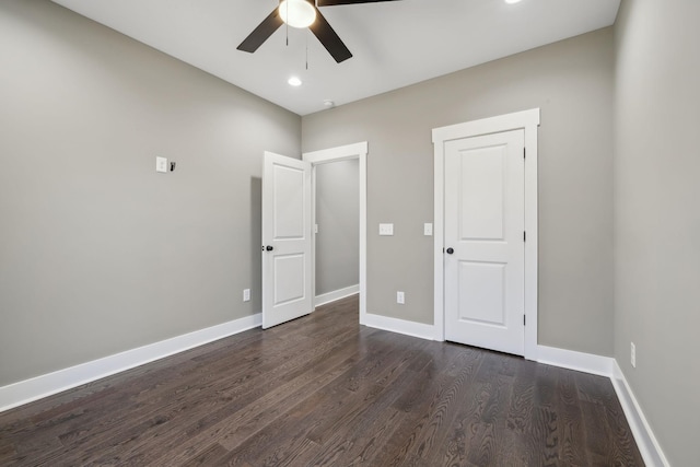 unfurnished bedroom featuring a ceiling fan, baseboards, and dark wood-style flooring