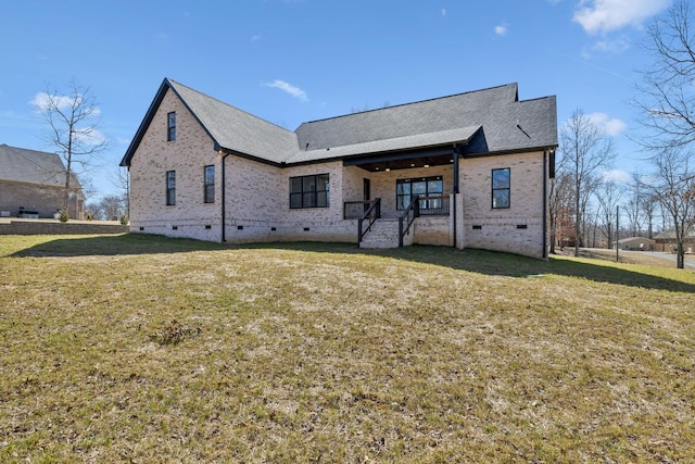 back of property featuring crawl space, brick siding, and a yard