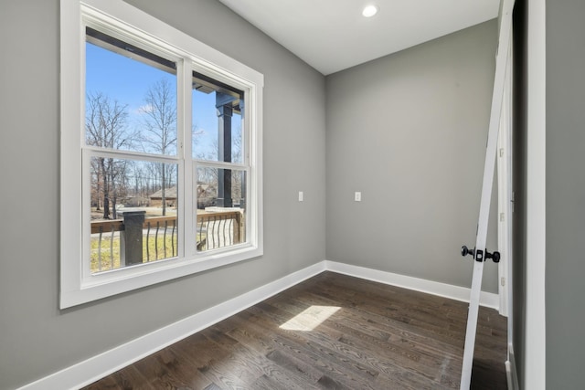 empty room featuring dark wood-type flooring and baseboards