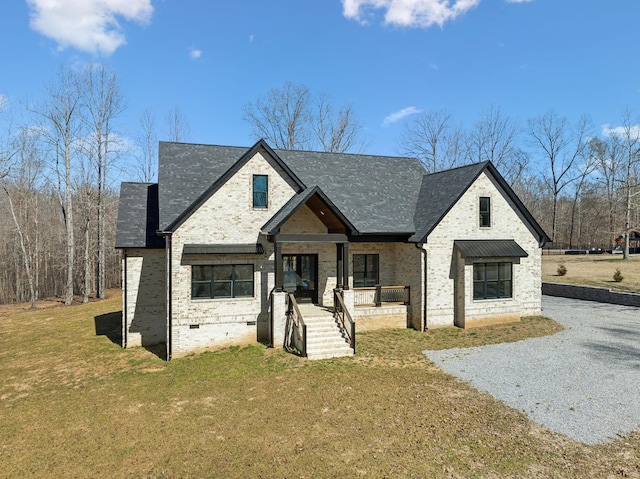 view of front of property featuring a porch, a front yard, gravel driveway, and brick siding