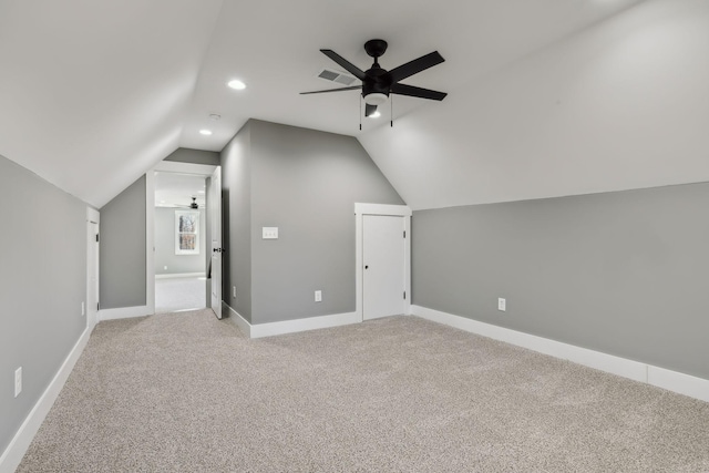 additional living space featuring light carpet, baseboards, vaulted ceiling, and a ceiling fan