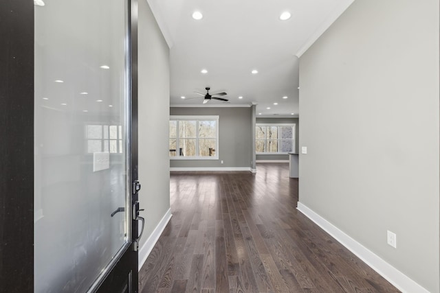 hall with dark wood-style floors, recessed lighting, crown molding, and baseboards