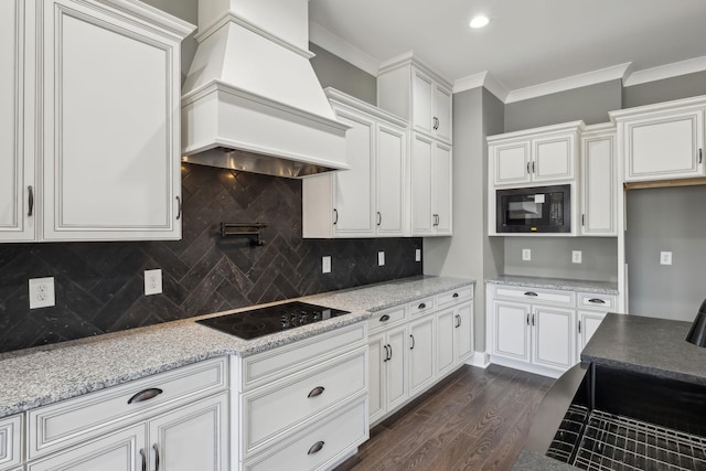 kitchen featuring white cabinetry, custom exhaust hood, dark wood-style floors, black appliances, and crown molding