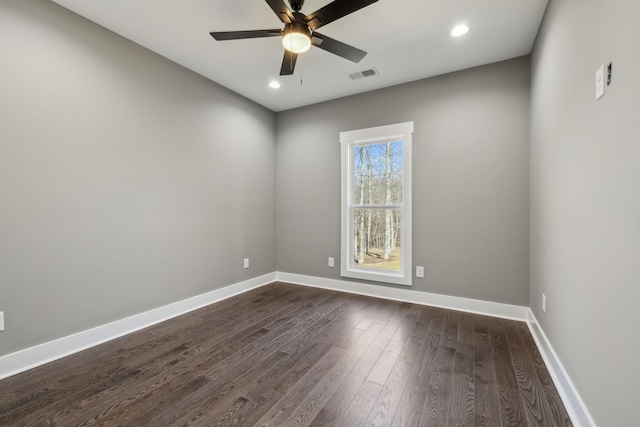 spare room featuring dark wood-style floors, baseboards, visible vents, and ceiling fan