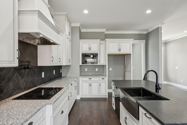 kitchen with ornamental molding, dark wood-style flooring, black appliances, premium range hood, and a sink