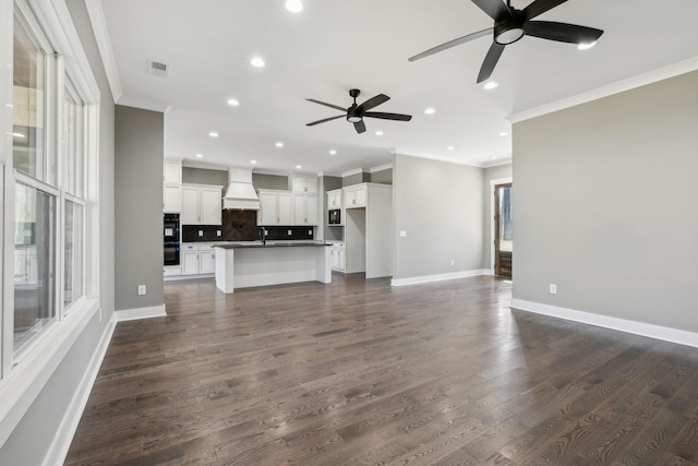 unfurnished living room with baseboards, visible vents, ornamental molding, dark wood-style flooring, and recessed lighting