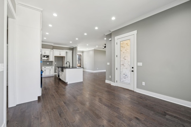 unfurnished living room featuring ceiling fan, recessed lighting, dark wood-type flooring, baseboards, and crown molding