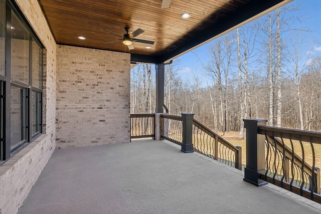 exterior space featuring ceiling fan and a view of trees