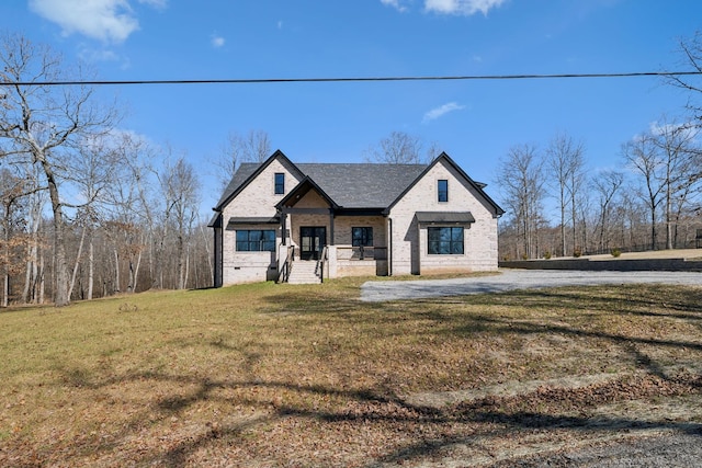 view of front of house featuring a front lawn, crawl space, a shingled roof, and brick siding