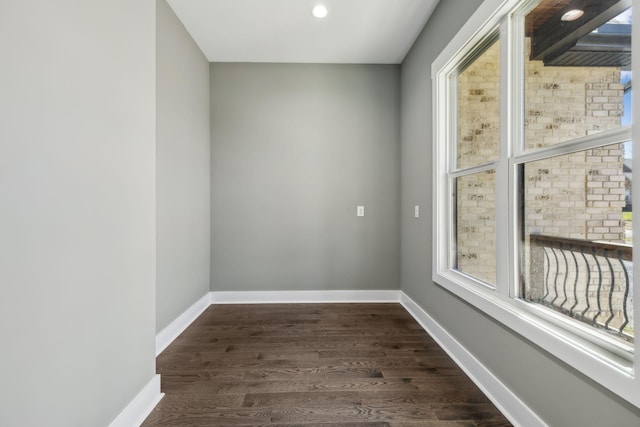 empty room featuring dark wood finished floors and baseboards