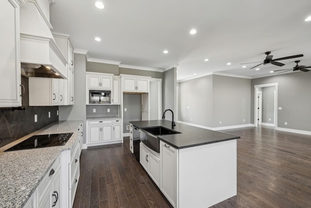 kitchen with black appliances, dark wood-type flooring, a sink, and crown molding